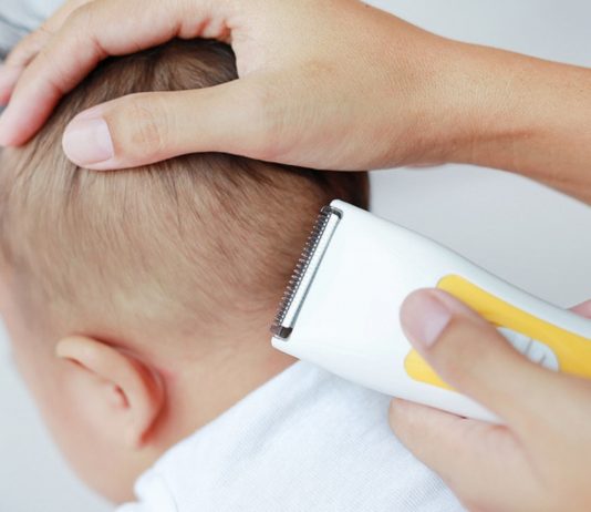 Mutter beim Baby Haare schneiden mit der Haarschneidemaschine