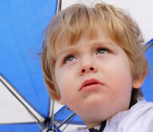 kleiner Junge unter dem Regenschirm