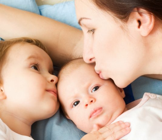 Mama kuschelt mit ihren beiden Kindern