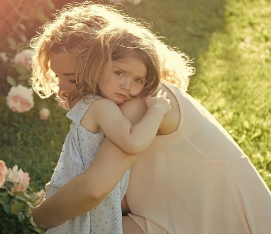 Mama und ihre Tochter nehmen sich in den Arm