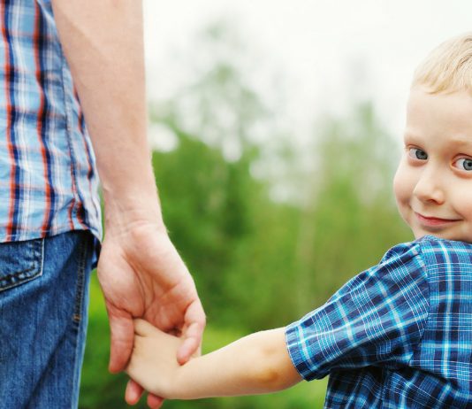 Papa und sein Sohn halten sich an der Hand