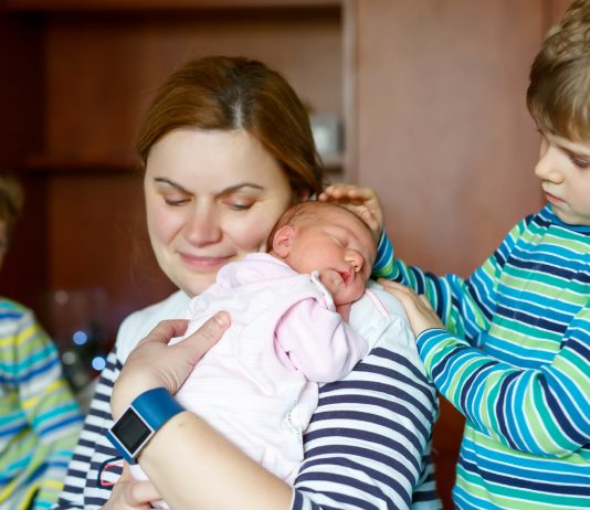 Mama mit ihrem Neugeborenen und ihren Söhnen