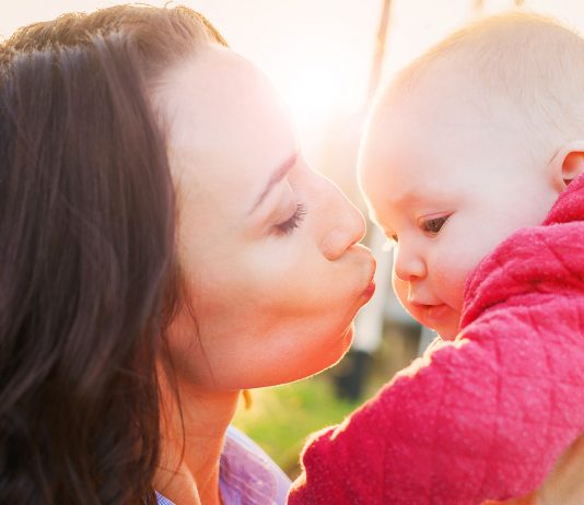 Mama gibt Baby einen Kuss