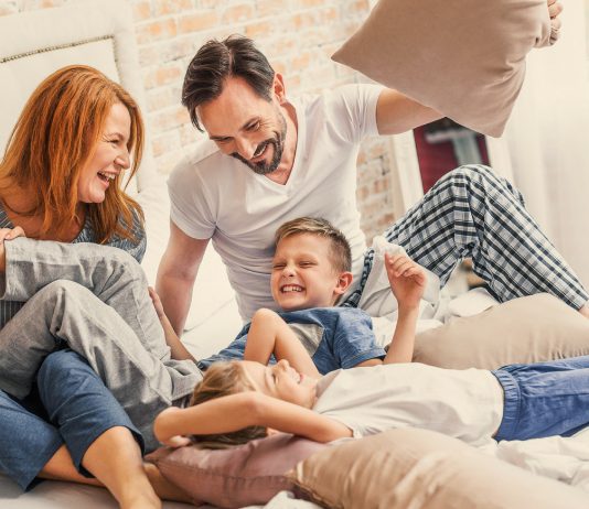 Familie tobt im Bett