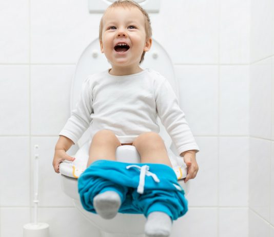 Kleiner Junge sitzt auf der Toilette