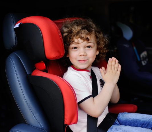 Junge sitzt im Auto in einem Kindersitz