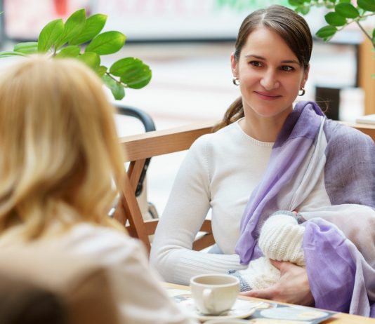 Frau stillt ihr Baby in einem Café