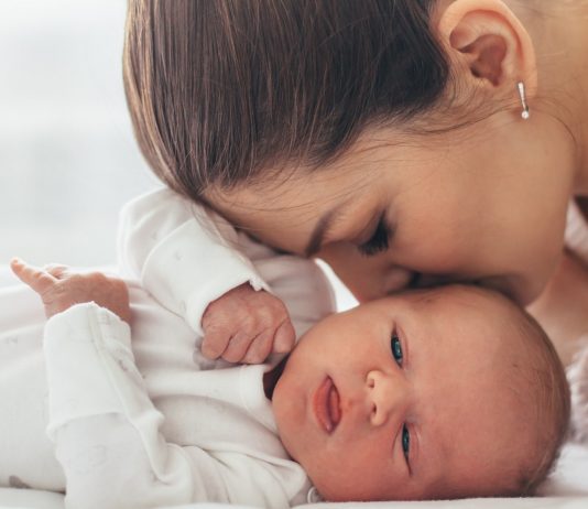 Mama gibt ihrem Baby einen Kuss