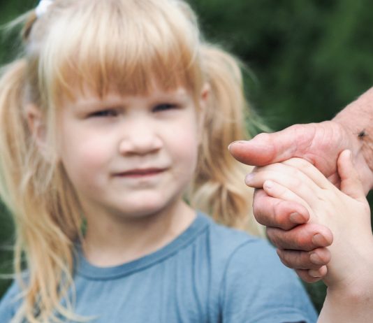 Mädchen hält die Hand von einem Mann