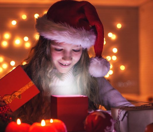 Mädchen packt Geschenke aus