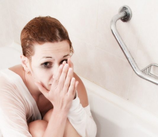 Frau sitzt verzweifelt in der Badewanne.