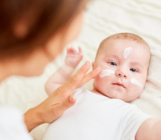 Muttermilch-Creme: Baby mit Cremetupfen im Gesicht