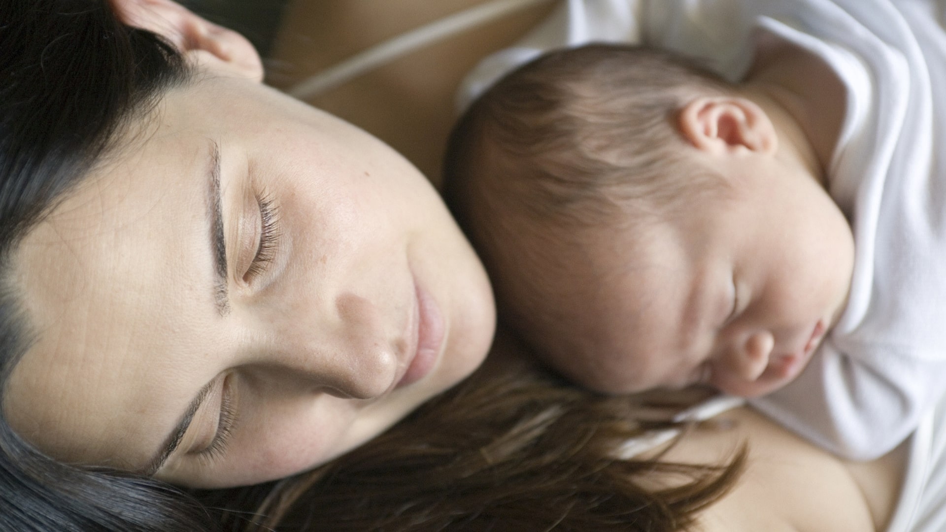 Kuschelzeit: Baby schläft auf Mamas Bauch