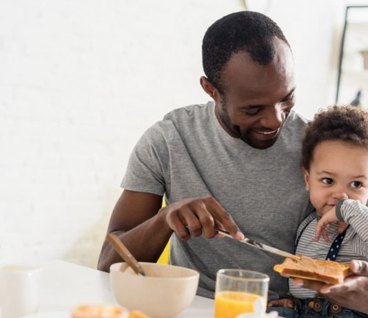 Vater frühstückt mit Baby