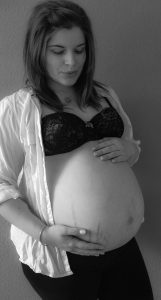 Schwangere mama mit Dehnungsstreifen auf dem Babybauch