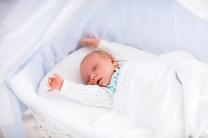 Baby mit Moro-Reflex streckt Ärmchen in die Luft