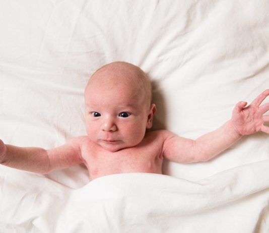 Baby mit Moro-Reflex reißt Ärmchen hoch
