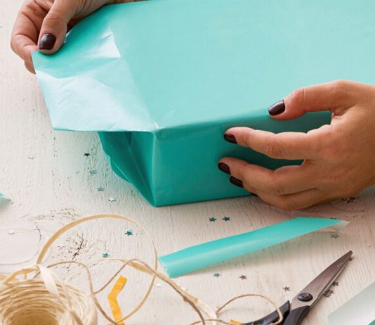 Geschenke verpacken für Kinder; Frau verpackt Geschenke