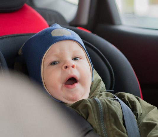 Winterjacken im Kindersitz: Junge im Auto