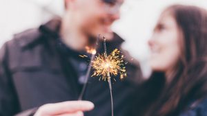 Schwanger an Silvester: Paar hält Wunderkerzen.