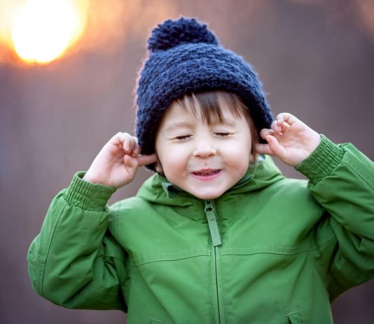 Silvester Angst Kleinkind: Kind hält sich die Ohren zu.