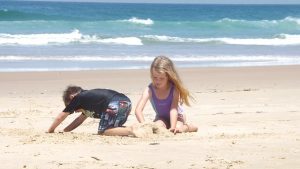 Kinder spielen im Familienurlaub am Strand