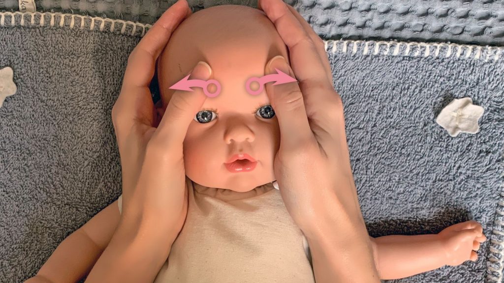 Babymassage Anleitung: Die Stirn sanft seitlich ausstreichen.