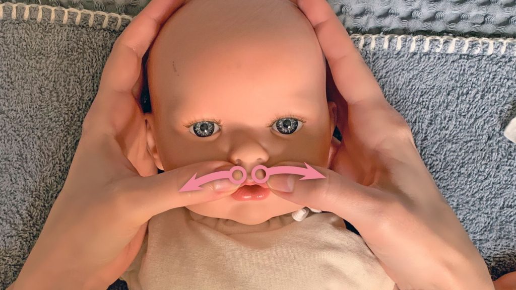 Babymassage Anleitung: Die Stelle zwischen Nase und Mund von innen nach außen streichen.