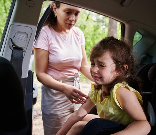 Junge Mutter mit niedlichen kleinen Mädchen Kind im Auto spielen