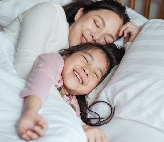 Mutter und Tochter kuscheln im Bett