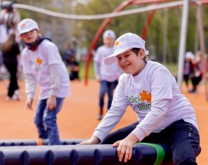 A boy plays and laughs in the inclusive play area of Stück zum Glück