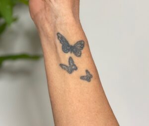 Andrea hat sich ein Tattoo stechen lassen, das für ihre drei Kinder steht.