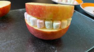 Die Mini-Marshmallows werden die Zähne des Halloween Apfel Monsters.