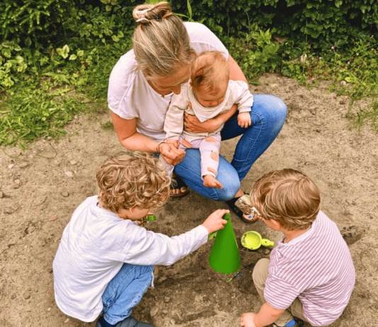 Mama spielt mit Kindern im Garten