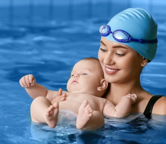 Mama und Baby fühlen sich in einem Babyschwimmkurs sichtlich wohl.