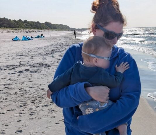 Larissa mit Aaron am Strand.
