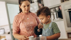 Mama und Kind bereiten gemeinsam Essen zu.