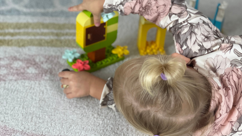 Mädchen baut einen Baum mit LEGO DUPLO.