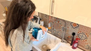 Sarah gießt das Schmutzwasser vom Wischen aus.