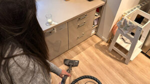 Sarah wischt verschüttete Milch vom Küchenboden auf.