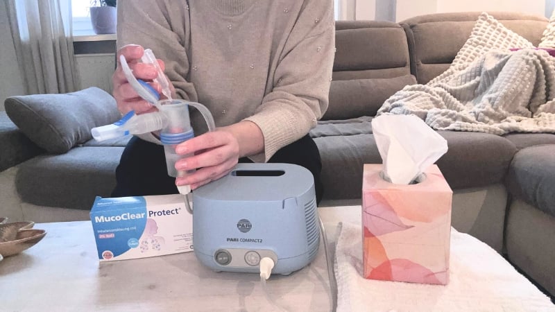 Eine Mutter befüllt das Inhalationsgerät PARI COMPACT2 mit einer Kochsalzlösung.