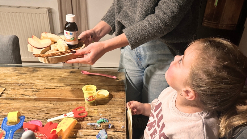 Mama stellt einen Obstteller auf den Tisch