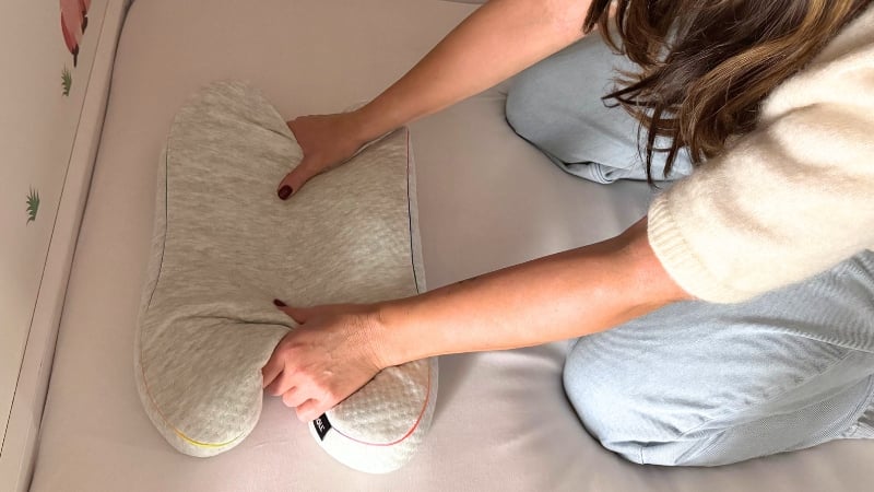 Mama sitzt auf dem Bett und überpüft das Kissen